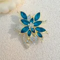 Macro detail of gold floral brooch featuring dark blue marquise stones and paved rhinestones - Light Blue (XZ99)