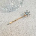 Detailaufnahme einer goldenen Schneeflocken-Haarklammer mit glänzenden Strasssteinen - Kleiner Stern-Stil (J009-01) / Gold