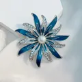 Vista dettagliata della spilla a fiore argento con smalto blu scuro e una perla bianca centrale - Stile Girasole Blu