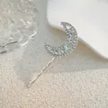 Detail einer mondförmigen Haarspange aus Metall mit Strasssteinen auf Keramiktablett - Mondform-Stil (J009-01) / Silber