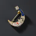 Detailed close-up of a smiling crescent moon brooch with white crystals and gold base - Gold Style / Gold Moon