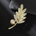 Detalle de broche de hoja dorada con brillantes de imitación y una perla de imitación - Hojas Doradas
