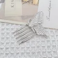 Eleganter silberner Schmetterlings-Haarkamm mit fünf Zähnen auf weißem Strukturhintergrund - Schmetterlings-Design / Silber