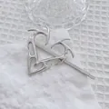 Dettaglio del fermaglio per capelli cuore fiamma Y2K argento con finitura metallica lucida - Argento Sinistro