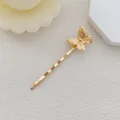 Vista dettagliata del fermaglio a farfalla dorato con trame incise di alta qualità - Stile Piccola Farfalla / Oro
