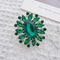Macro view of French luxury brooch with green crystals and oval emerald glass stone - Green Flower
