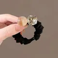 Détail d'un élastique à cheveux noir avec perle ambrée et grand cristal de coupe carrée - Style Perles Brillantes et Strass / Café Clair Translucide