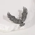 Minimalist antique silver eagle brooch with detailed feathers on a white stone background - Antique Silver