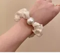 Detalle del coletero de encaje crema con adorno de perla grande para un estilo elegante - Beige Encaje Perla