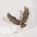 Vintage golden eagle brooch with detailed feathers on a minimalist stone background - Antique Gold