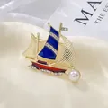 Detalle del broche de velero esmaltado con velas azules, pedrería y una perla blanca - Azul