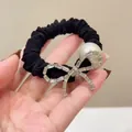 Elegant black scrunchie with a large pearl and sparkling rhinestone bow detail - Bow Style