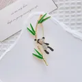 Dettaglio della spilla panda e bambù con strass scintillanti e smalto verde raffinato - Un Panda