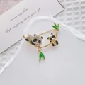 Macro di una spilla a forma di panda con strass scintillanti su rami di bambù - Xz237 Due Panda