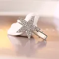 Silver star hair clip with pavé rhinestones on a minimalist ceramic bird display - Silver
