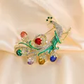 Elegant colorful peacock brooch with vibrant gemstones and crystals on champagne silk - Colorful Peacock Style