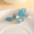 Elegante fermaglio per capelli a farfalla dorata con smalto blu e perla decorativa - Orchidea Blu