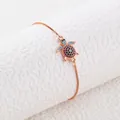Dettaglio macro del bracciale a tartaruga in oro rosa con zirconi colorati incastonati - Oro rosa