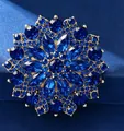 Dettaglio della spilla a girasole con cristalli blu intenso e petali dorati di lusso - Girasole Blu