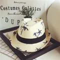 Beige straw panama hat with navy palm tree prints and a black ribbon band for summer - Beige