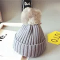 Bonnet en tricot gris foncé pour bébé avec un grand pompon en fausse fourrure - Gris