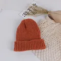 Flat lay of caramel knit beanie for toddlers with soft vertical stripe texture and cuff - Caramel color