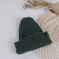 Detailed close-up of dark green rib-knit beanie hat featuring a thick folded cuff - Green