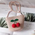 Handmade woven straw crossbody bag for girls with cute 3D red crochet cherry accents - Pink