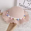 Pink girls straw hat with colorful pom-poms and wavy brim for summer sun protection - One Size / Pink Straw Hat