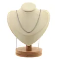 Détail d'un collier chaîne box argenté présenté sur un support en velours beige - Or blanc