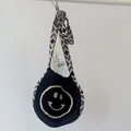 Black and white knit shoulder bag for children featuring a smiling face and geometric strap - Black