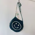 Deep green knitted crossbody bag for kids featuring a white smiley face and tribal patterns - Dark Green