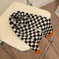 Black and white checkerboard knit scarf for kids with orange edges on a chair - Black & White Color Block Grid