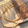 Detail of layered gold snake chain and beaded necklace with polished metallic texture - Gold Set