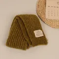 Olive green chunky knit scarf with white woven label on a minimalist background - Dark Green