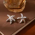 Polished silver starfish stud earrings with 3D texture on a vintage book surface - Silver Starfish Puffy 3D Earrings (S2426-1)