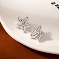 Pair of silver star-shaped earrings with textured metallic finish on white ceramic - Silver Hammered Lava Star Earrings (S2492-1)