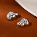 Minimalist silver wing-shaped metal stud earrings with polished finish on warm surface - Silver Streamlined Three-Petal Wing Earrings (S2511-2)