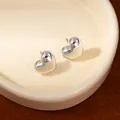 Minimalist polished silver puffed heart stud earrings presented on a ceramic plate - Silver Puffy 3D Heart Stud Earrings (S2518-1)