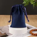 Dark blue velvet drawstring jewelry pouch on white circular stand with soft lighting - Navy Blue