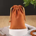 Warm orange velvet drawstring pouch for jewelry storage on a white platform - Orange
