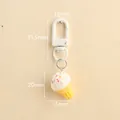 Resin ice cream keychain with white cream top and colorful sprinkles on wood background - White