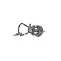 Detailed macro view of skull charm with black pave-set stones and 24K gold lobster clasp - Platinum