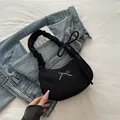 Schwarze gerippte sichelförmige Schultertasche mit weißer Schleifenstickerei und Detail - Schwarz