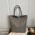 Classic woven gray leather tote bag with elegant handles for daily commute - Gray