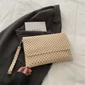 Détail d'un sac à main crème chic avec motifs géométriques et dragonne assortie de luxe - Monogramme Kaki