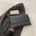 Détail macro de la pochette enveloppe à motif géométrique avec dragonne sur costume - Monogramme Vintage Noir