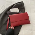 Detail of red envelope clutch bag in smooth PU leather with detachable metal wrist strap - Burgundy