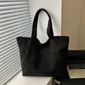 Borsa tote vintage in velluto a coste nero con tasca frontale in un ambiente da ufficio - Nero