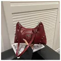 Detalle del bolso de hombro en cuero encerado rojo oscuro con remaches y hebilla - Rojo